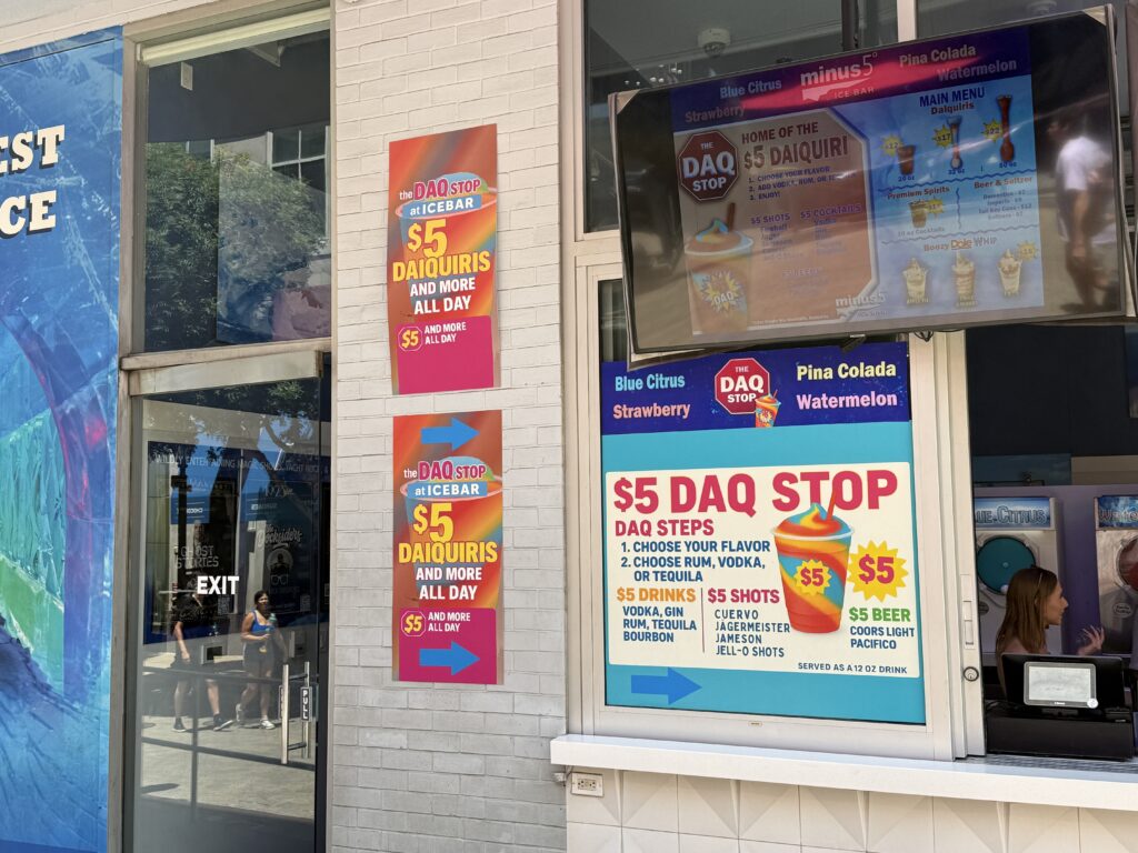 A sign advertising $5 daquiris and spelling out flavor and booze options. 