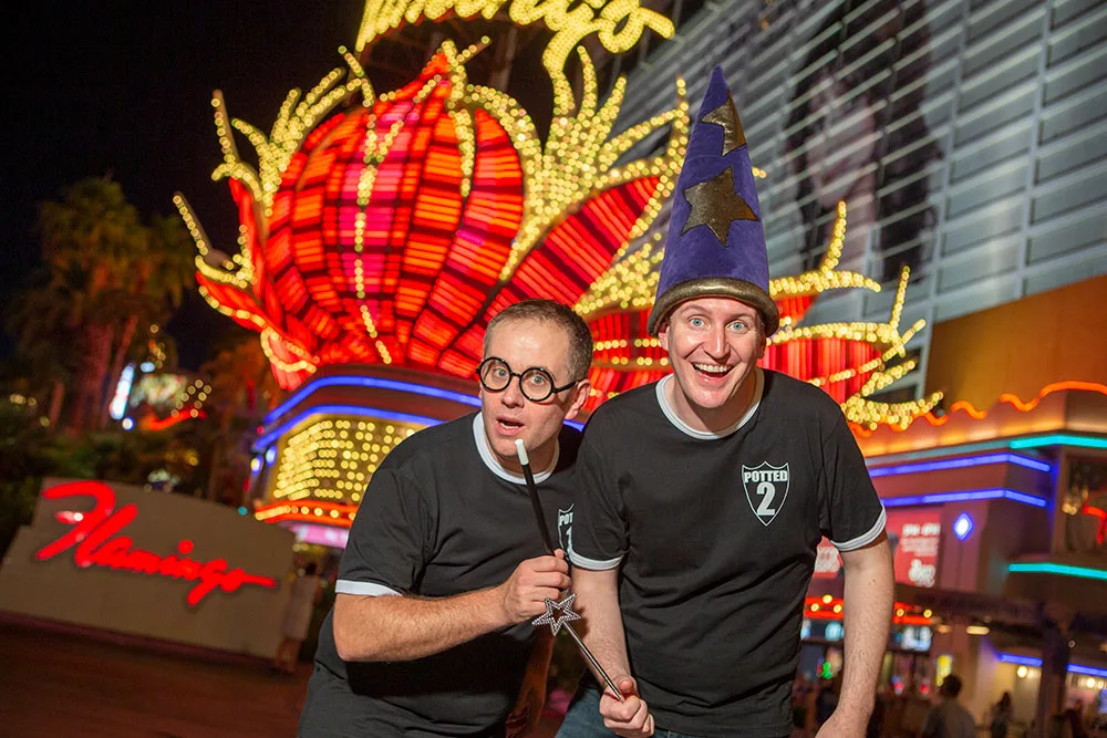 2 performers from Potted Potter pose outside Flamingo at night