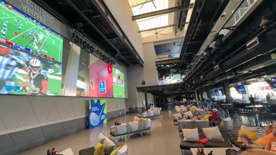 A massive video wall playing sports in Topgolf's atrium.