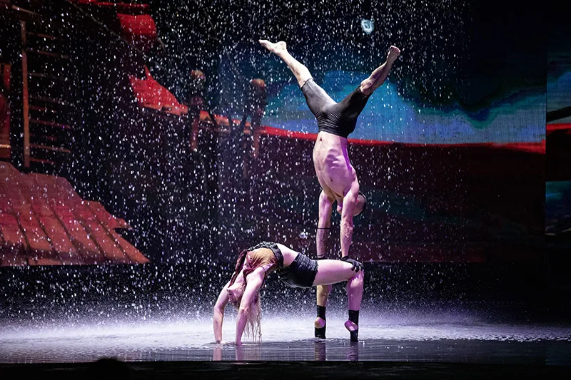 Man doing a hand stand on the back of another person