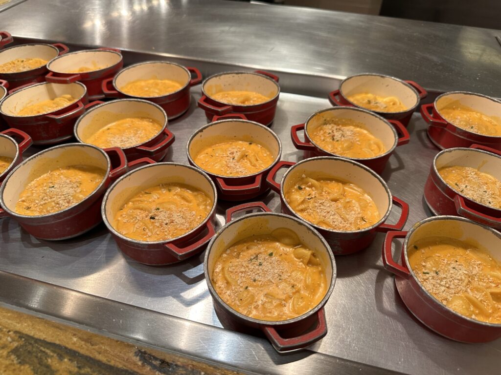 Little red individual pots of mac & cheese which have a cracker like dust sprinkled atop each.