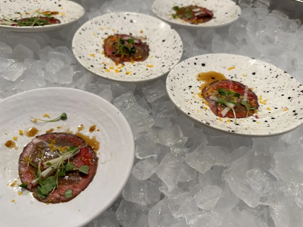 Beef Tataki at Wicked Spoon in individual plates which are set atop a bed of ice. 