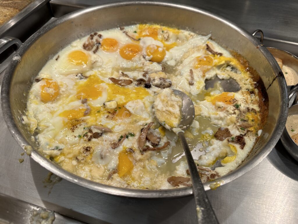 A communal bowl of braised eggs with a serving spoon sticking out. 