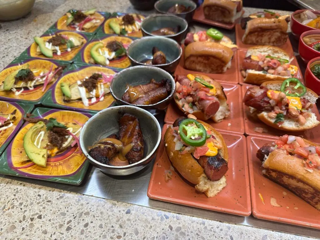 Duck quasadillas, fried plantains, and street style hot dogs on display.