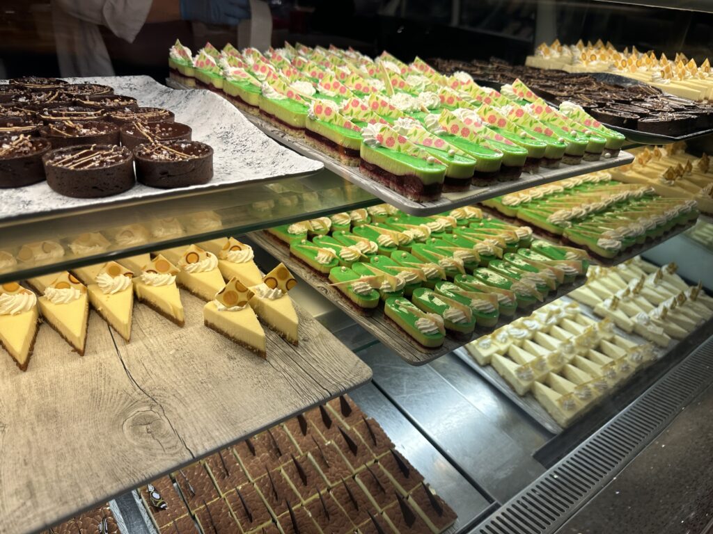 Numerous colorful pie varieties on trays in the pie counter portion of the dessert counter.