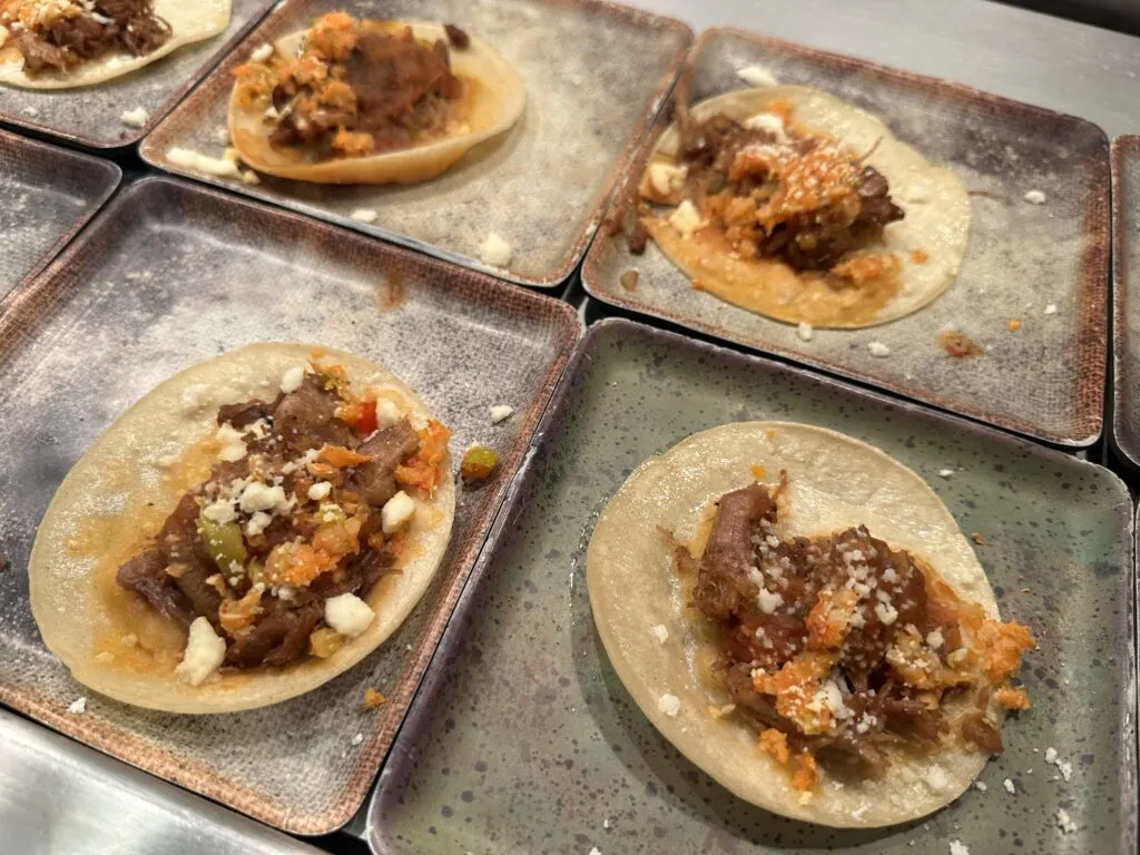 Individually plated pork carnitas tacos. 