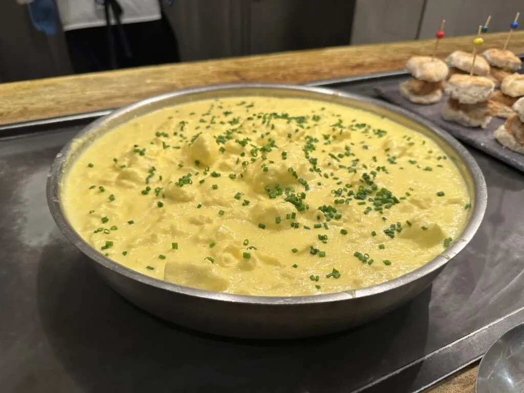 Scrambled eggs in a large bowl, topped with chopped chives. 