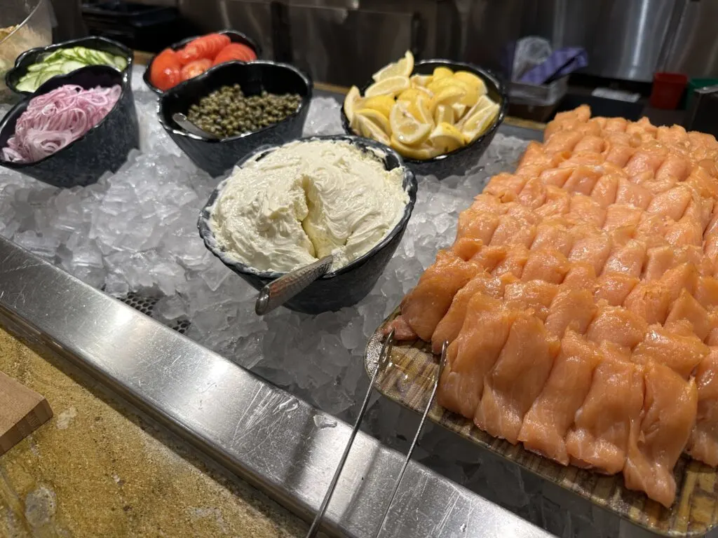 Smoked Salmon alongside fixings on a bed of ice. 