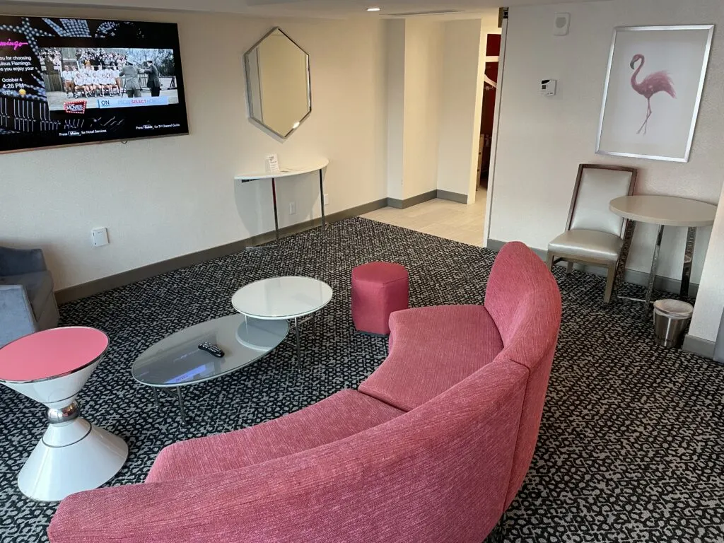 Couch and small table in the room with the TV on the wall