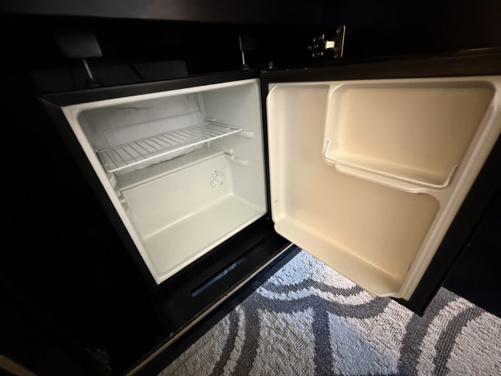 An empty mini fridge, open. 