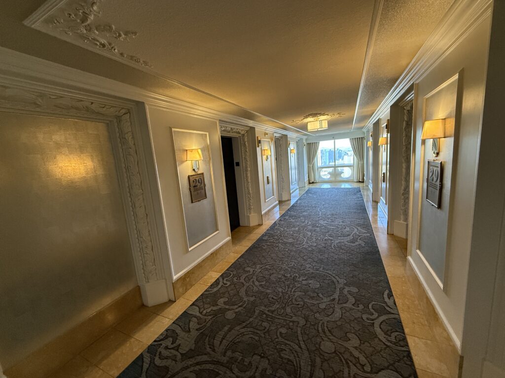 An elevator lobby on my hotel floor, which has the aesthetic of an upscale resort in (the real) Paris. 