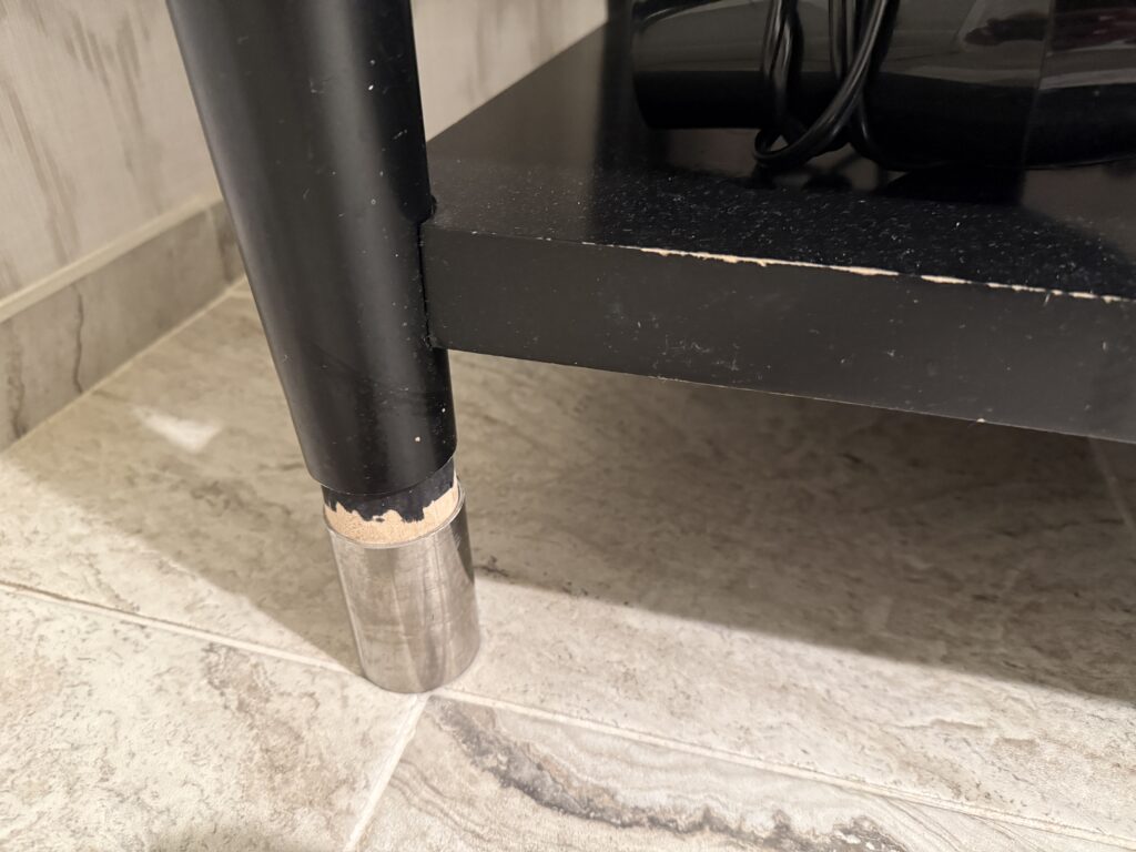 A scraped up leg of a vanity. 