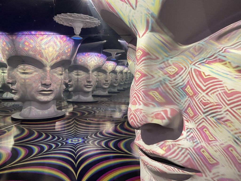 Face skulptures in a mirror room creating an infinity illusion