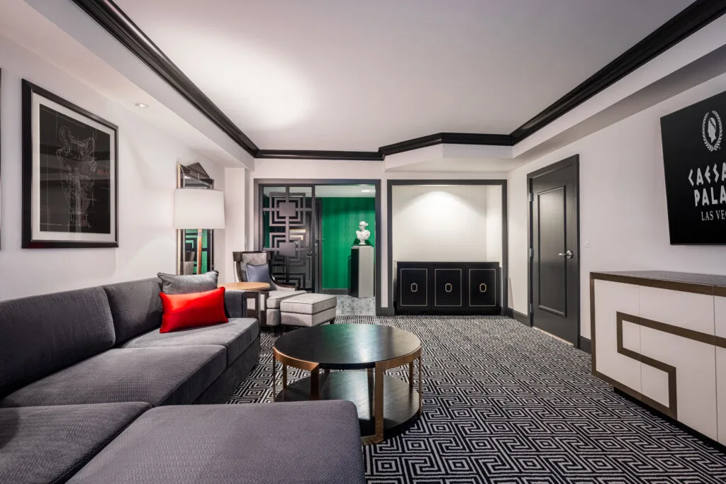 A living area, with a modern vibe, sectional couch pointed at a TV and black trim. 