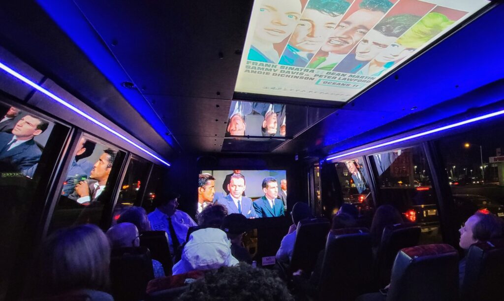 Tour bus with multiple movie screens playing Vegas movie clips