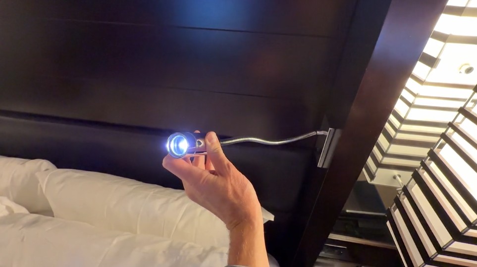 A reading light extending from the bedframe. 