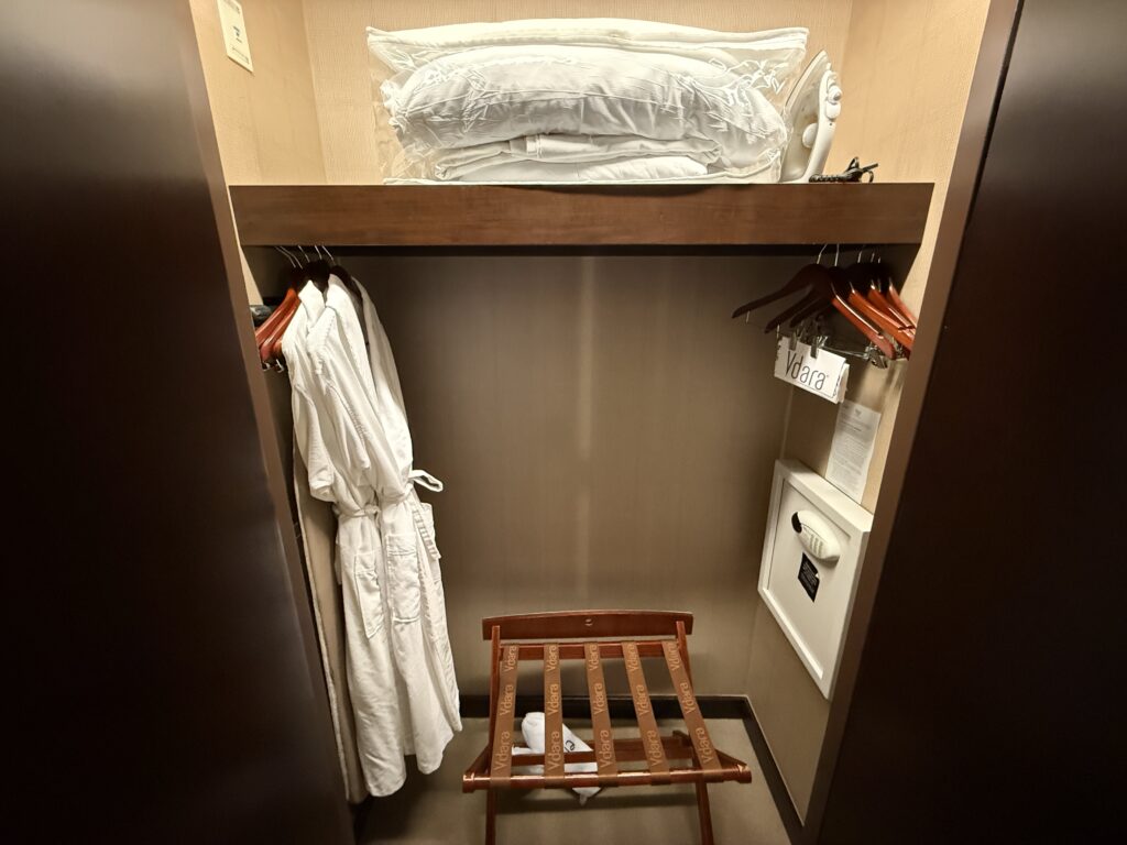A closet with robes, and blankets for the pull out bed, and an ironing  board.