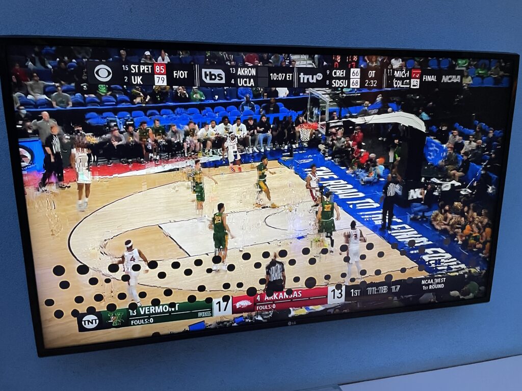 TV screen with 20 + black dots blocking the basketball game