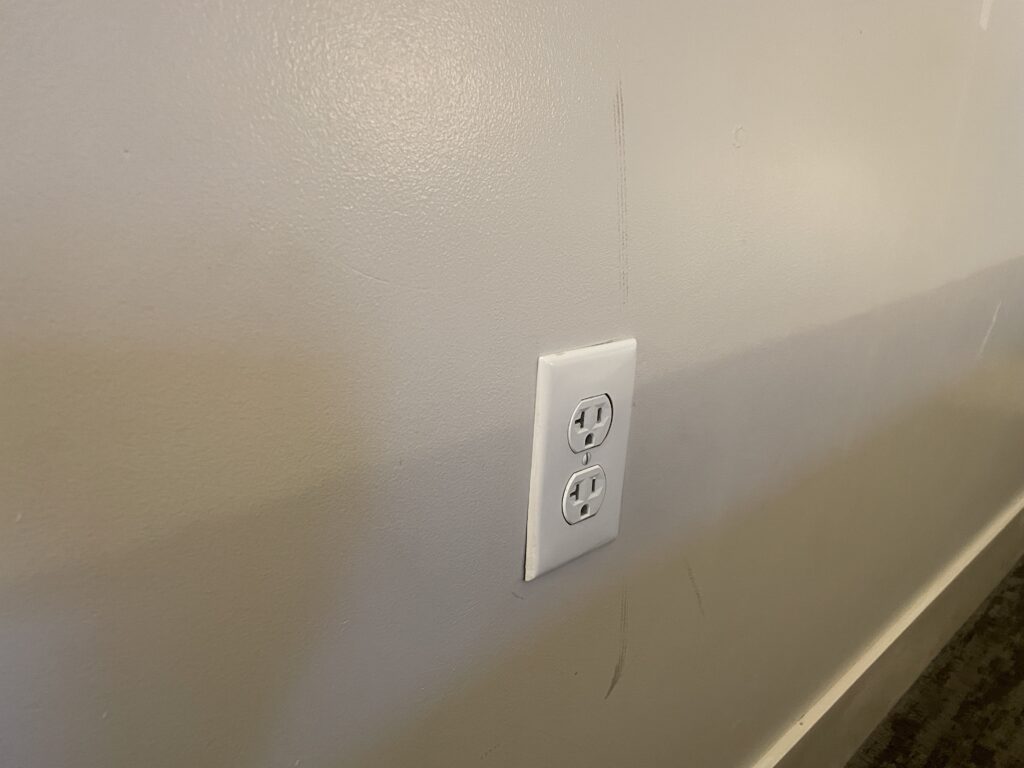 Scuffs on wall around a power outlet