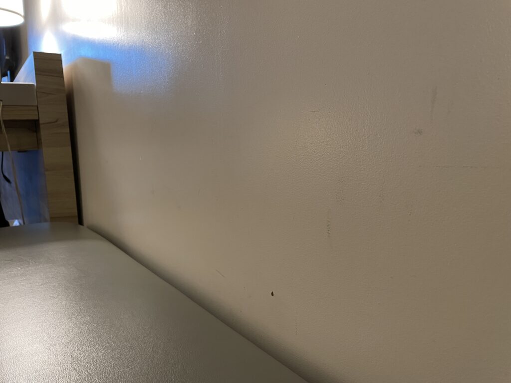 Scuffed wall above a bench