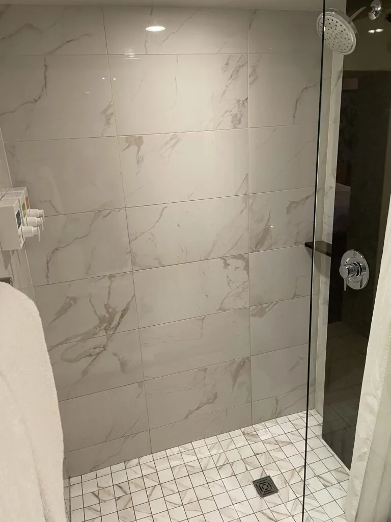 shower with a tiled floor and chrome fixtures