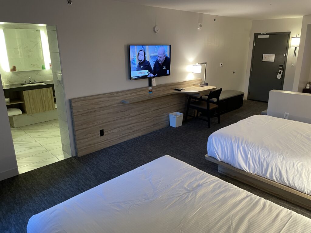 TV, queen beds, and door to the bathroom