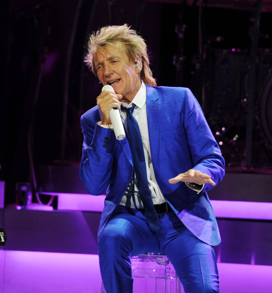 Rod Stewart singing into a microphone on stage