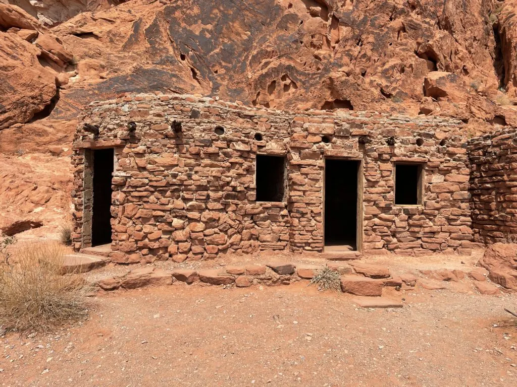 2 connected cabins constructed of red stones