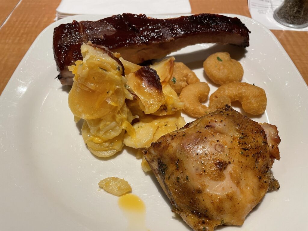 Ribs, poptatoes, fried shrimp, and chicken on a plate