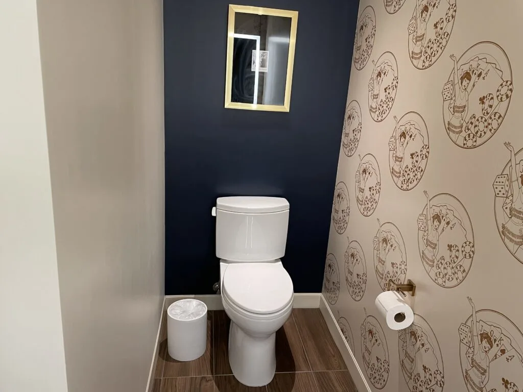 Toilet with a blue accent wall behind it