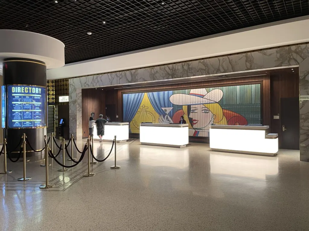 Hotel registration desk at Circa with artwork depicting Vegas Vickie behind the desk