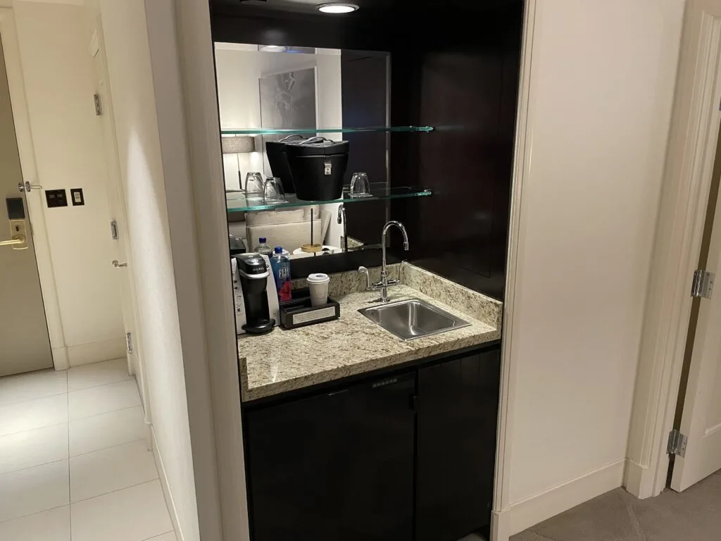 Wet bar with a small sink, coffee maker, and an ice bucket