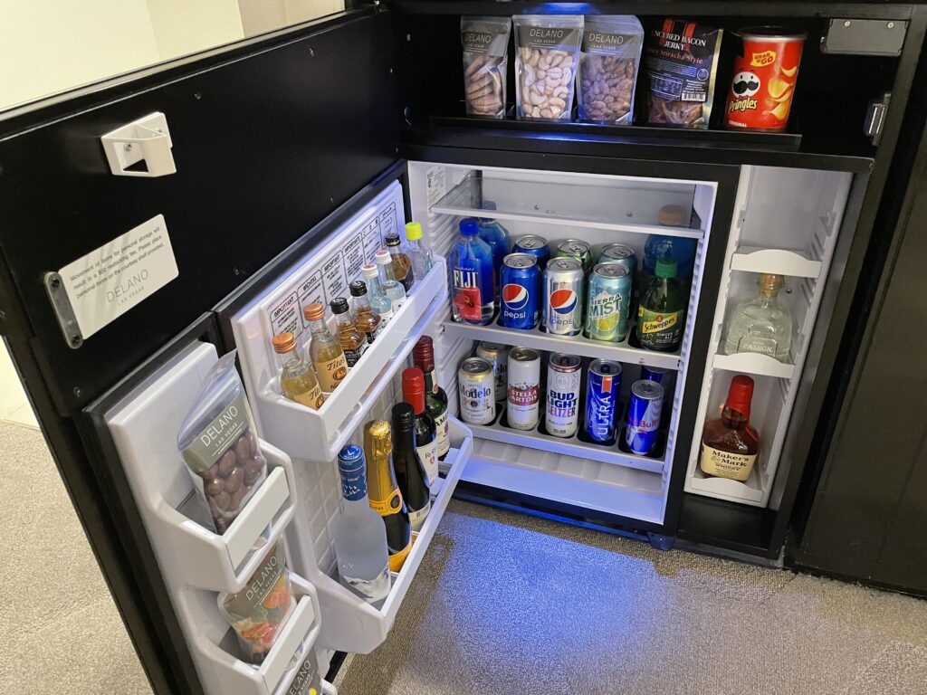 Mini bar fridge stocked with an assortment of beverages