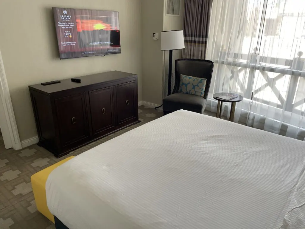 King bed with a TV mounted on the wall above a dresser