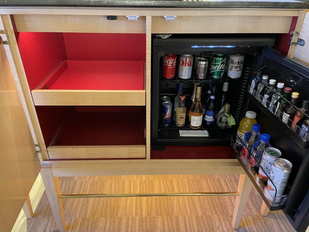 fridge inside a cabinet stocked with cold mini bar beverages