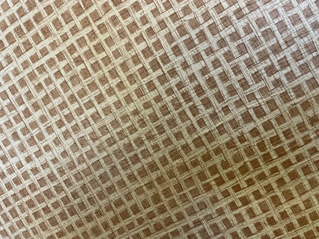 Wallpaper with a creme colored grid over tan squares