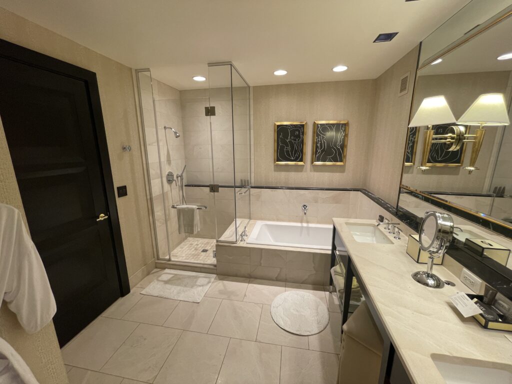 Glass enclosed shower in the bathroom next to a bathtub.