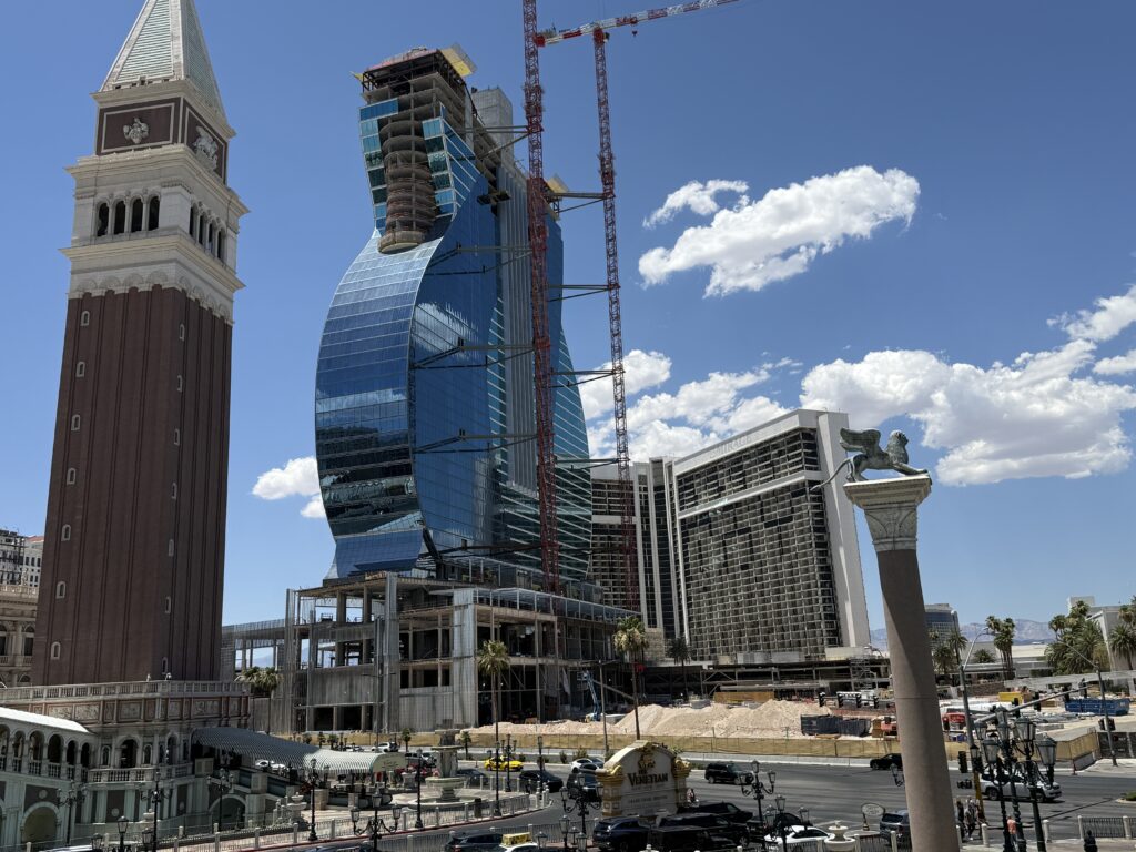 The guitar shaped hotel tower at Hard Rock, still under construction, but almost all the exterior glass has been hung. In the background, the former MIrage hotel structure is still sitting hallow, with now windows.