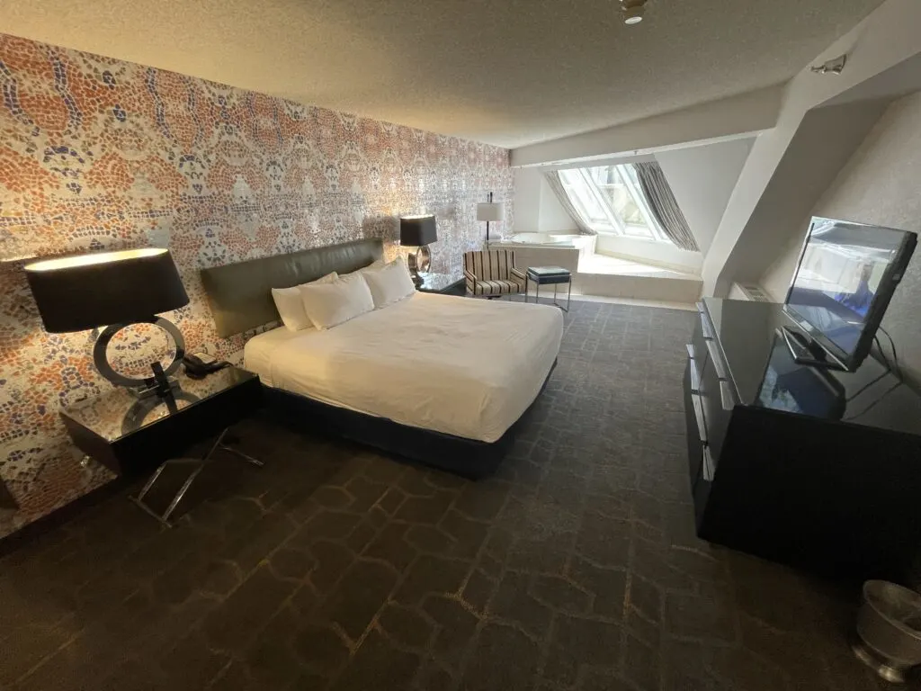 Another angle of the bedroom showing the king bed flanked by end tables with lamps atop them