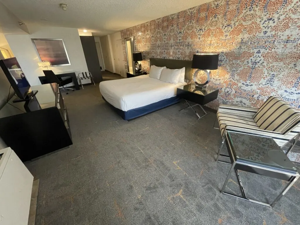 The bedroom with a king bed in the center of a flamboyant accent wall.