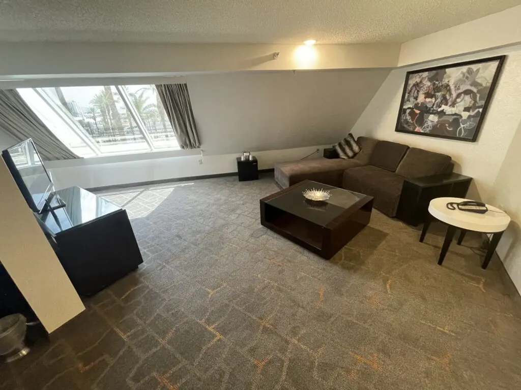 Living area with a couch and ottoman facing the TV stand