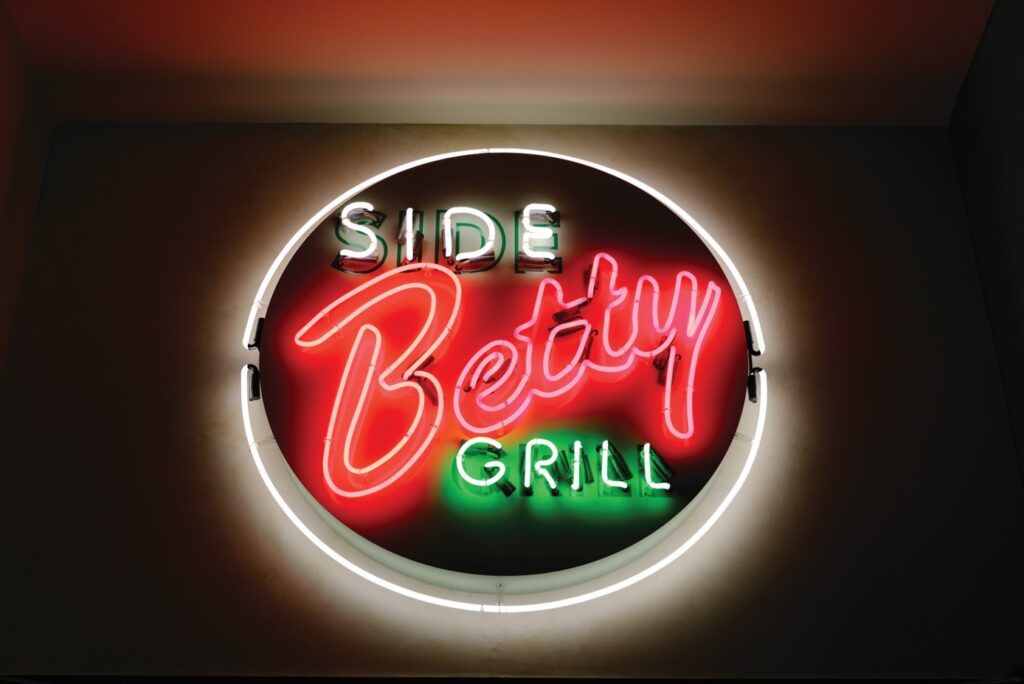 A neon sign for Side Betty Grill.
