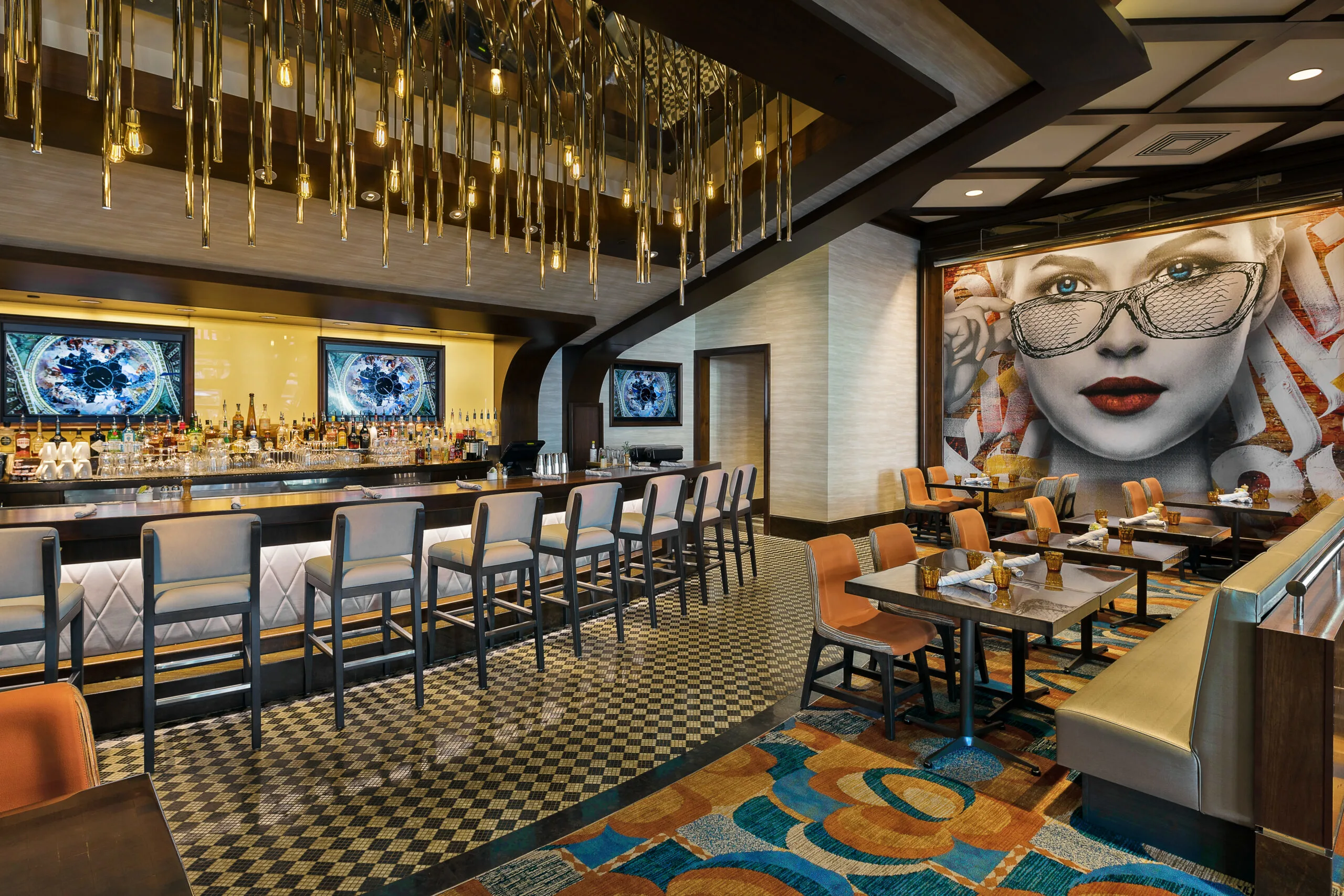 The bar at The Henry surrounded by unique portraits and hanging art.