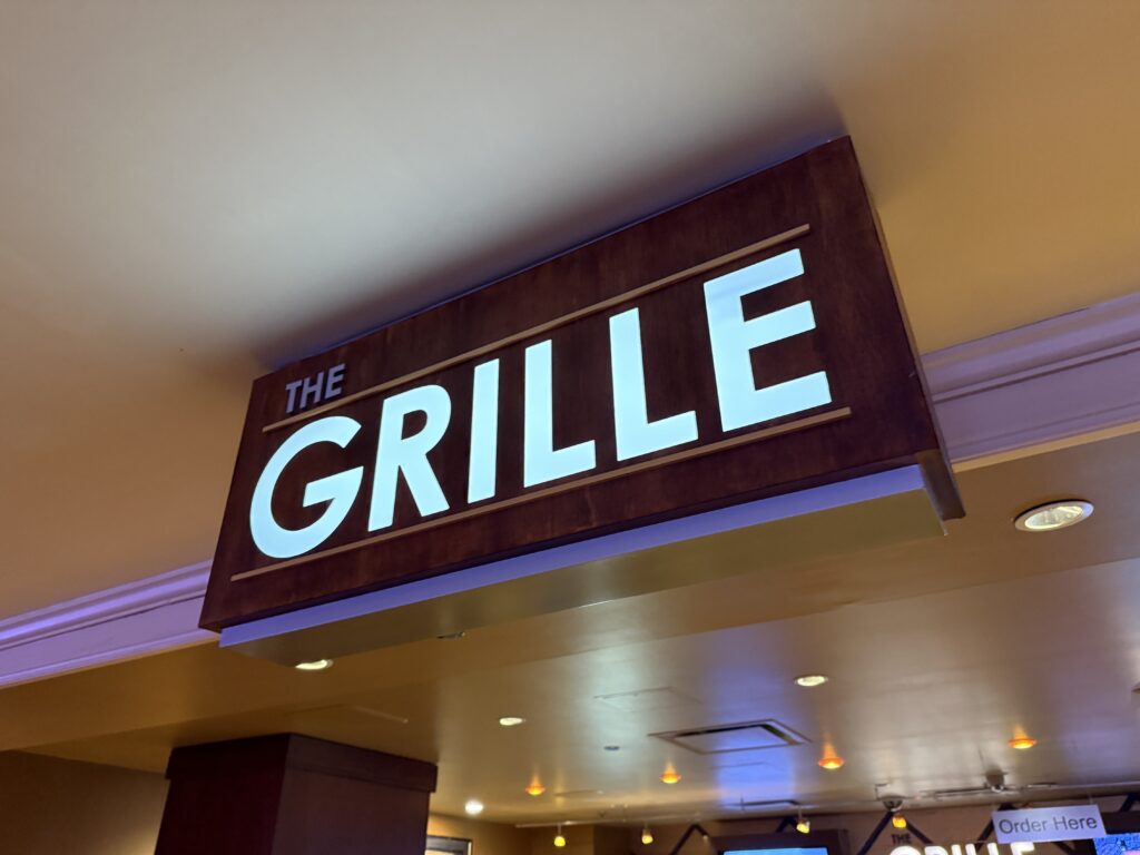 An illuminated sign on the ceiling that says "The Grille".
