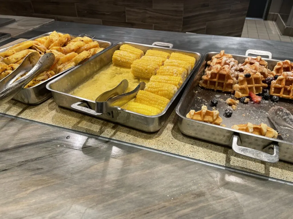 Waffles and roasted pinapples with corn in the cob between them