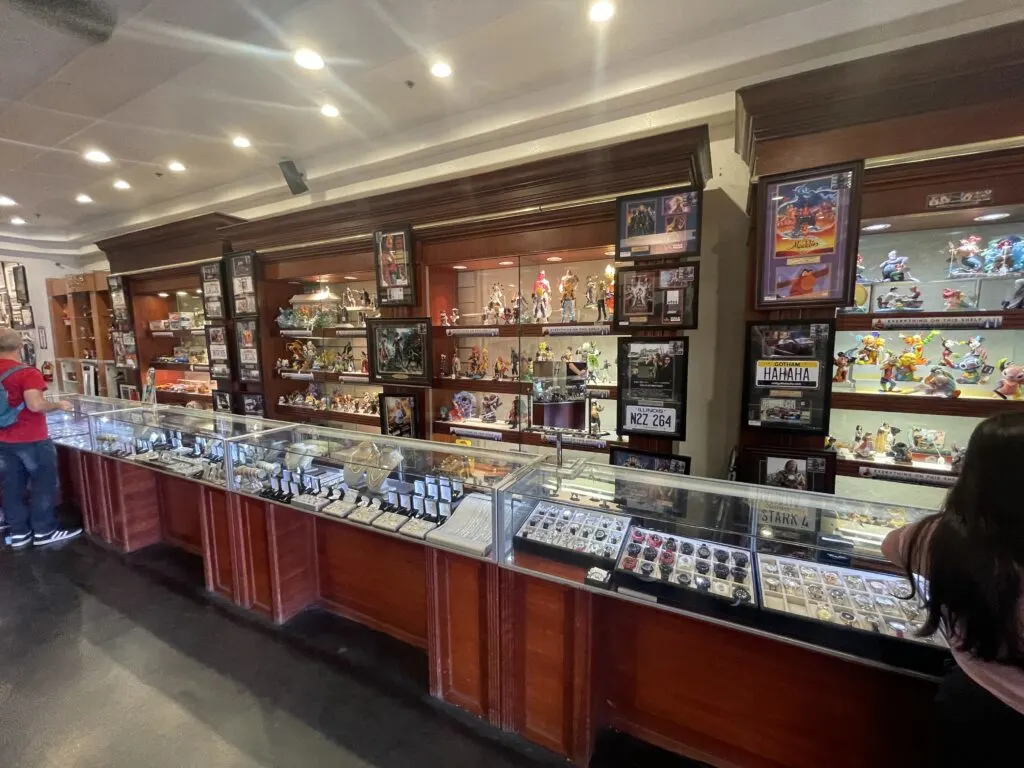 Display cases made of dark wood and glass along thw wall, packed with assorted merchandise