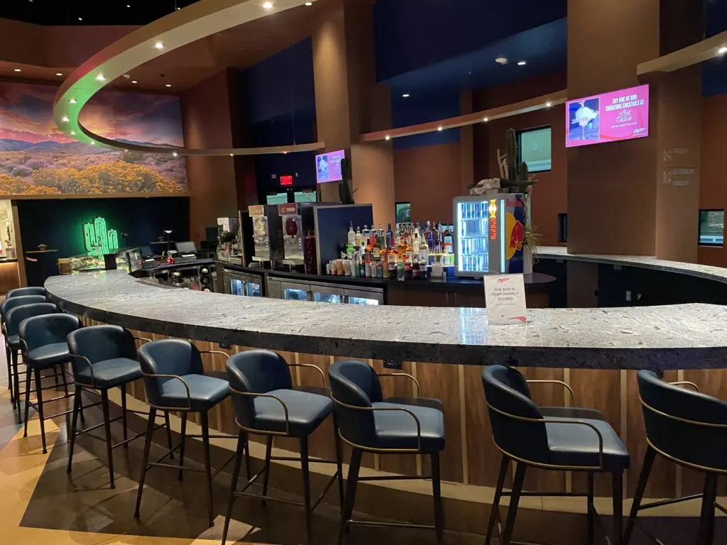 A bar with empty stools lined up across it. 