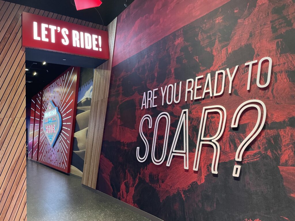 A large sign on the wall that says "Are you ready to soar? Lets Ride!"