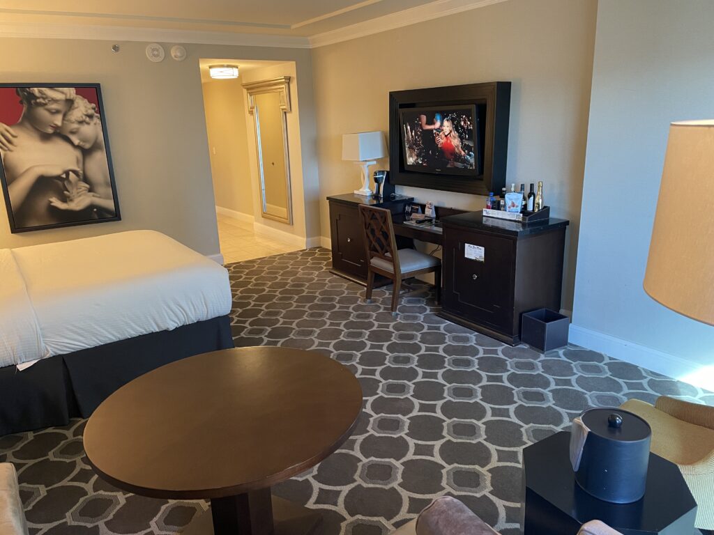 The room viewed from the couch in the living area, which has a view of the wall mounted TV. 