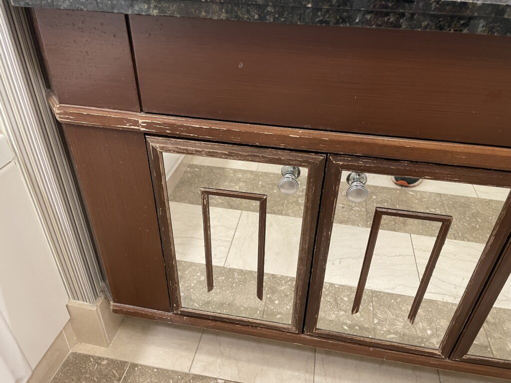 Close up of water damage & dings on the bathroom vanity wood.